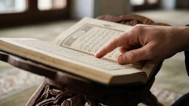 Rahle üzerindeki Kur'an'da satırları takip eden parmak