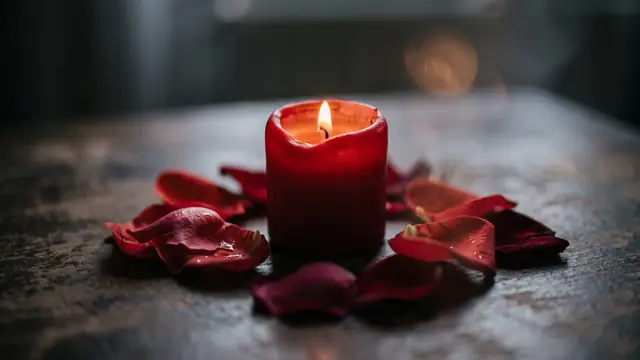 Bulanık rüya atmosferinde kırmızı mum ve gül yaprakları